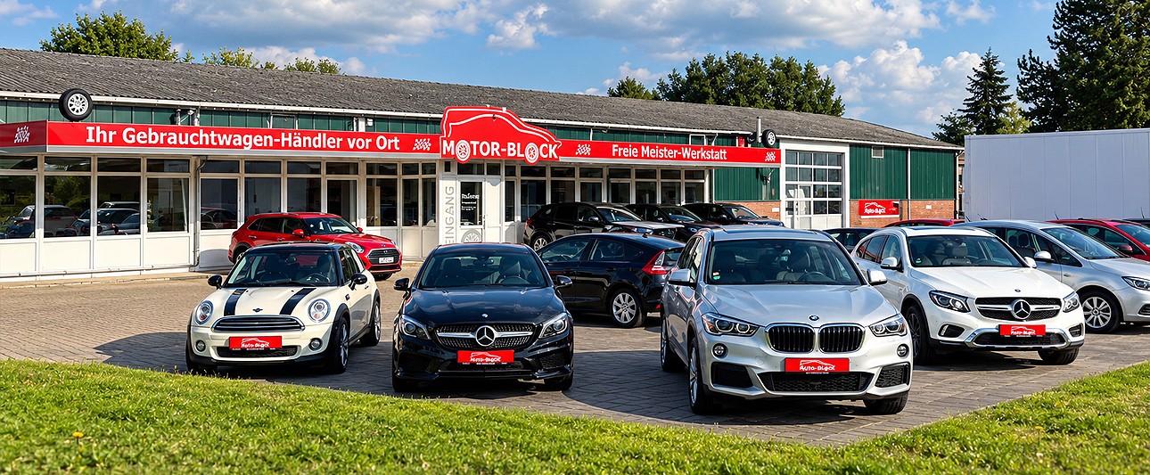 Gebrauchtwagen mit Firmengebäude im Hintergrund